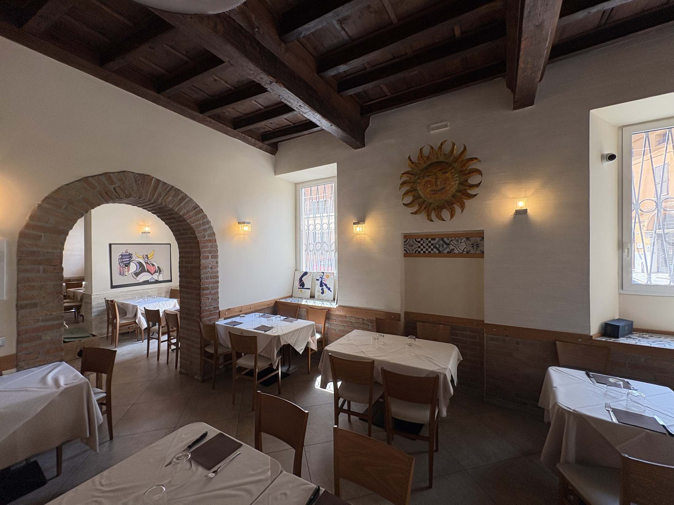 Sala interna di Estebar, ristorante a Ferrara dal 1975 - arco in mattoni e tavoli apparecchiati